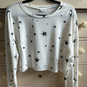 Cropped long sleeve white shirt with black stars.